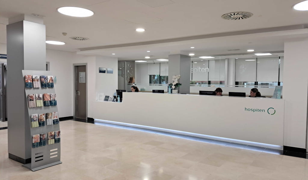 Recepción de hospital Hospiten en Tenerife con mostrador y folletos.