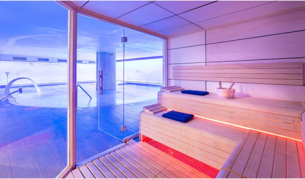 Sauna de madera junto a piscina interior en un spa de Tenerife.