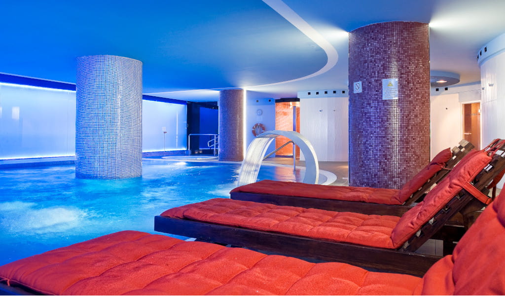 Zona de spa con piscina y tumbonas en hotel de Tenerife.