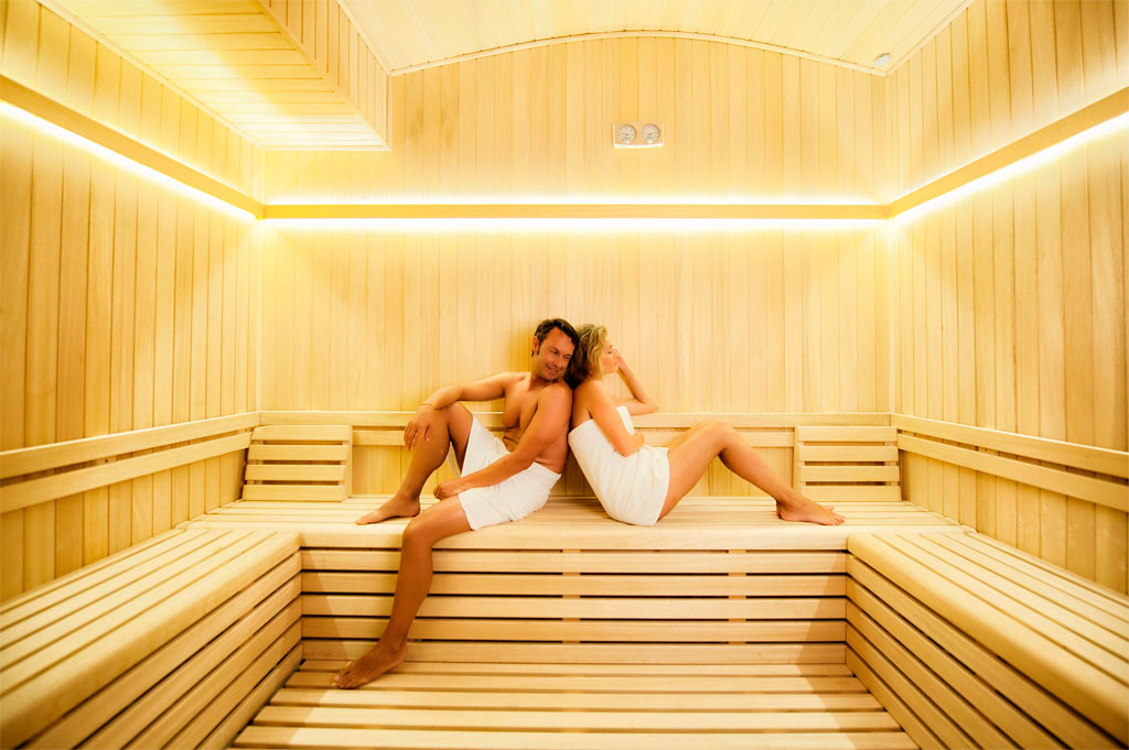 Pareja relajándose en una sauna de madera en un spa en Tenerife.