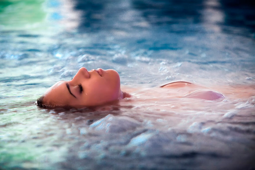 Persona flotando boca arriba en el agua en un spa de Tenerife.