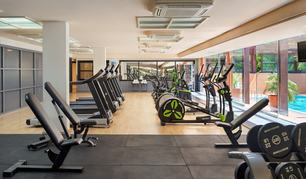 Gimnasio equipado con cintas de correr y bicicletas estáticas en hotel de Tenerife.