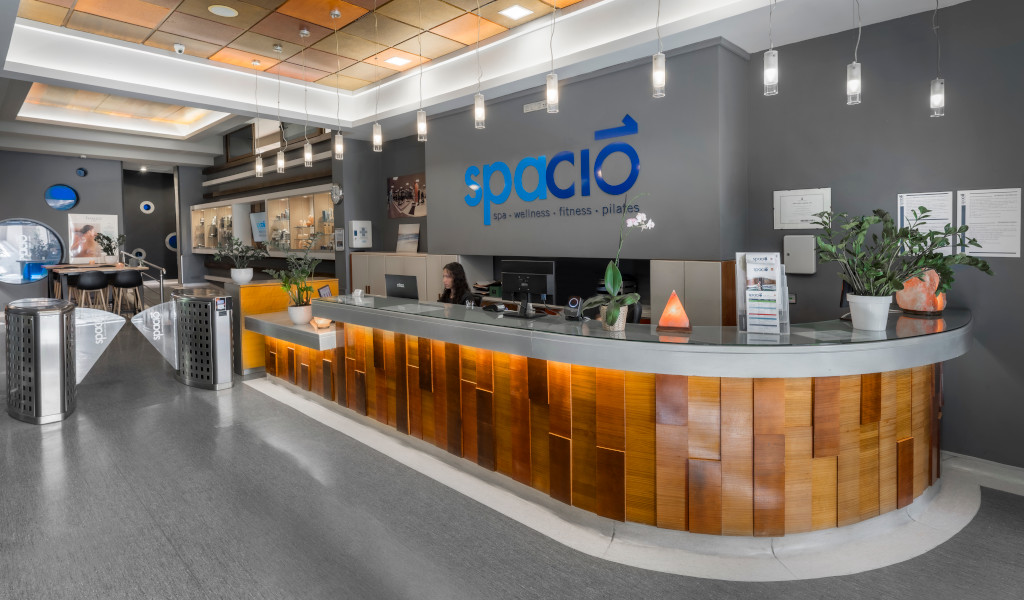 Recepción del spa Spacio en Tenerife con persona trabajando y planta decorativa.