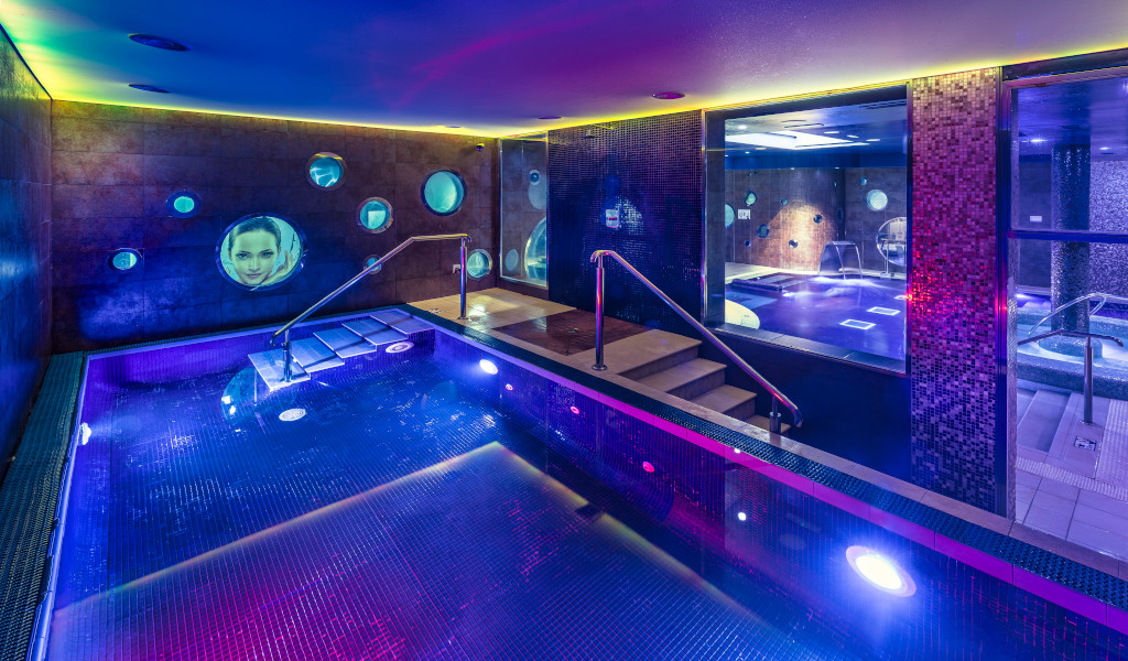 Piscina con iluminación en spa en Tenerife con proyecciones en las paredes.