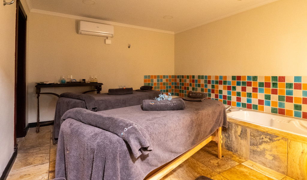 Sala de masajes con dos camillas y bañera en un spa de Tenerife.