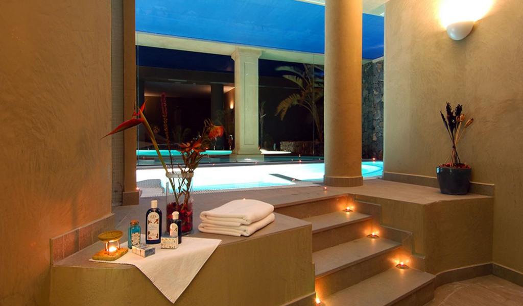 Piscina interior con flores, toallas y velas en resort de Tenerife.