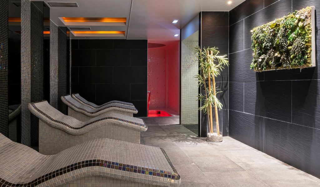 Sala de relajación con tumbonas y decoración vegetal en spa de Tenerife.