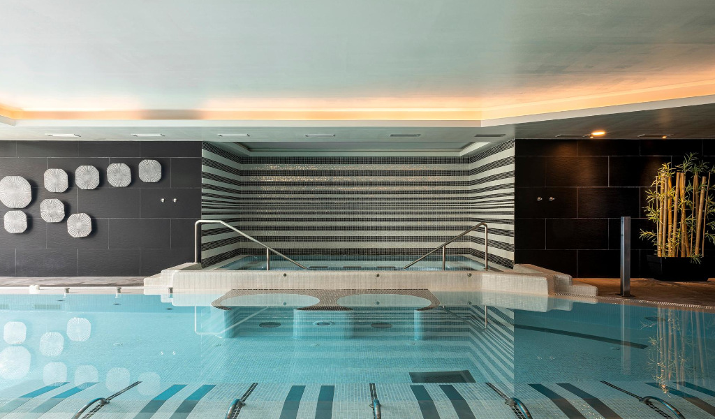 Piscina interior con diseño moderno y pared decorativa en Tenerife.