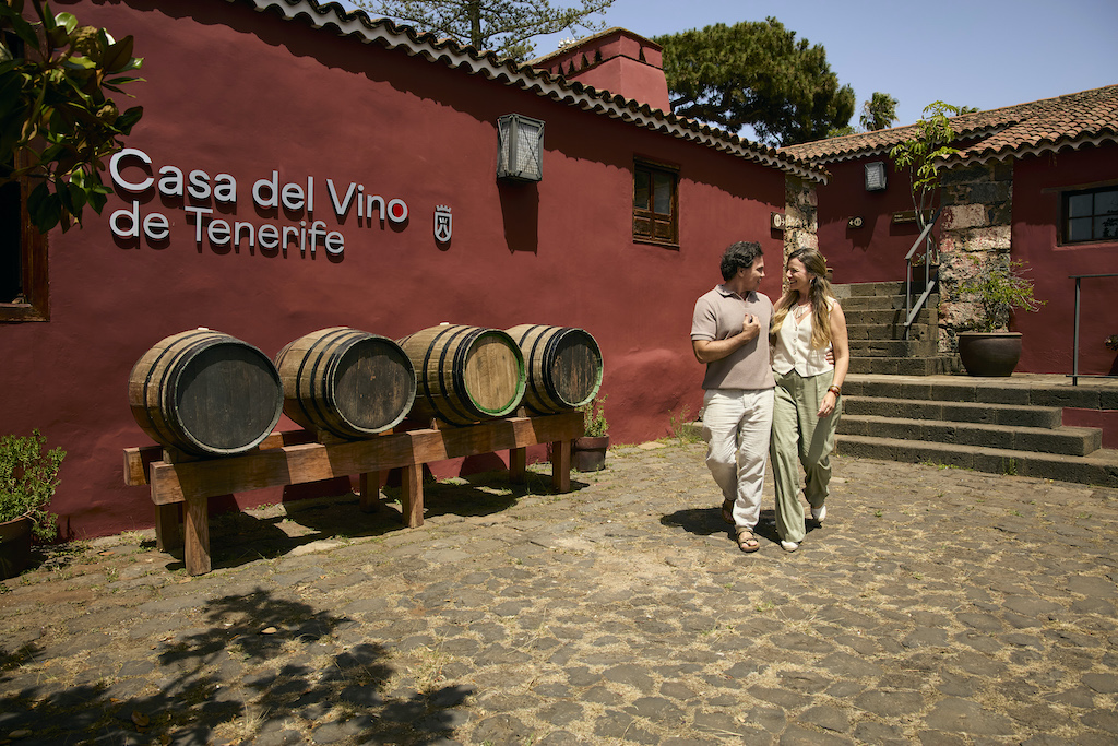 Pareja caminando junto a toneles en la Casa del Vino de Tenerife.