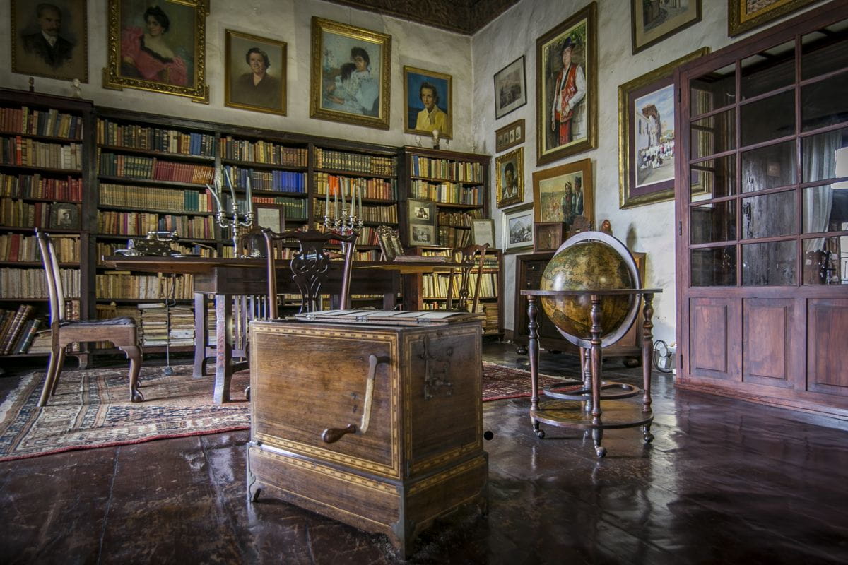 Biblioteca antigua con estantes llenos de libros y un globo terráqueo, en Tenerife.