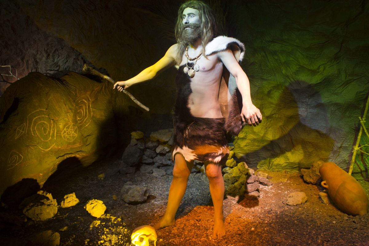 Hombre prehistórico con vestimenta de piel en una cueva, Tenerife.