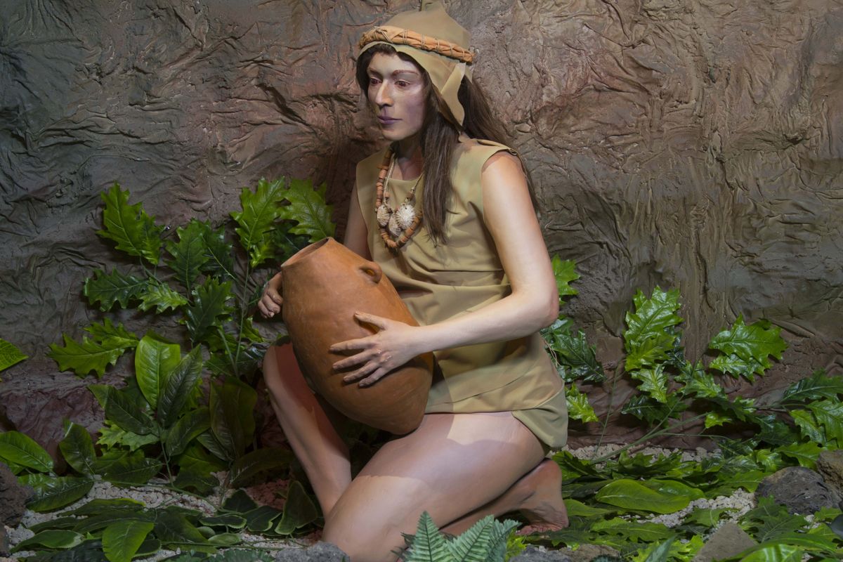 Mujer con traje tradicional aborigen sosteniendo una vasija de barro en Tenerife.