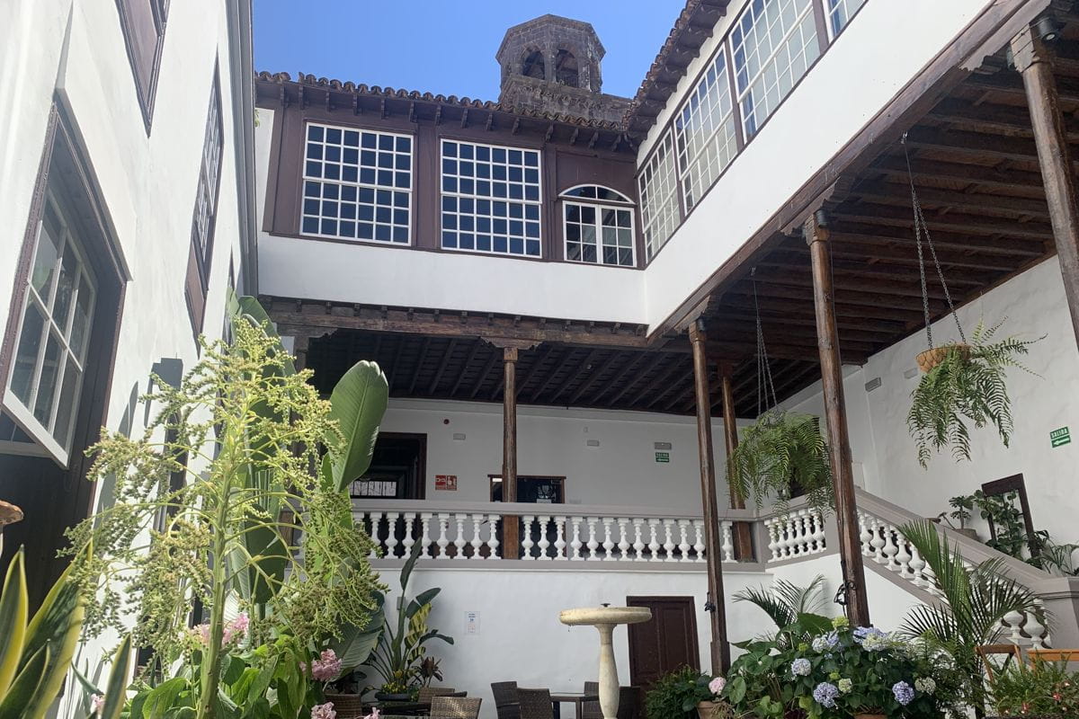 Patio interior con plantas y escaleras en edificio histórico de Tenerife.