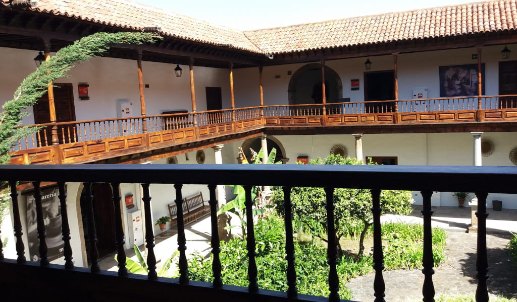 Patio interior con jardín y balcones de madera en La Laguna, Tenerife.