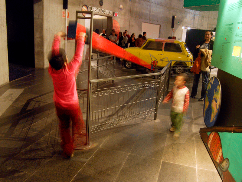 Niños jugando cerca de una exhibición sobre turismo cósmico en Santa Cruz de Tenerife.