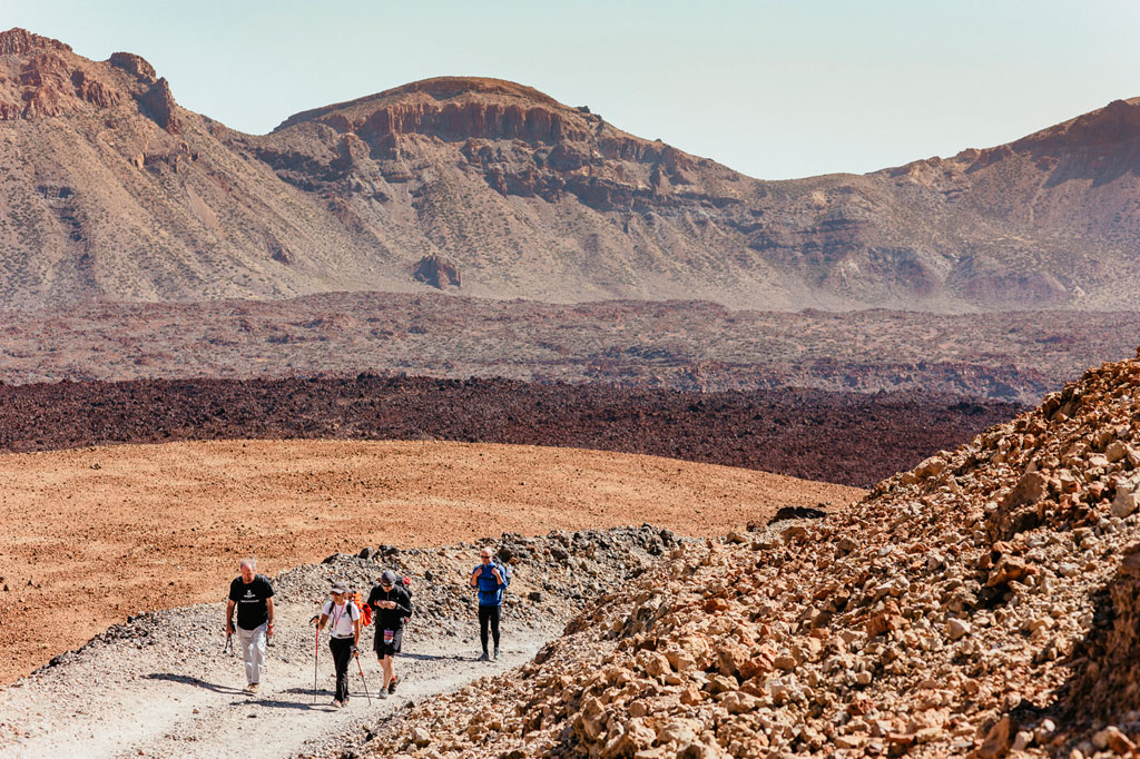 Senderistas en un sendero árido en el Parque Nacional del Teide, Tenerife.