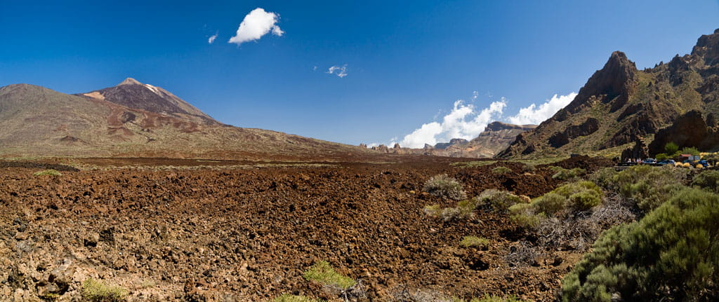 Paisaje volcánico con el Teide al fondo en Tenerife bajo un cielo despejado.