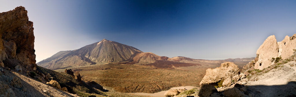 Paisaje del Teide rodeado de formaciones rocosas bajo un cielo despejado en Tenerife.
