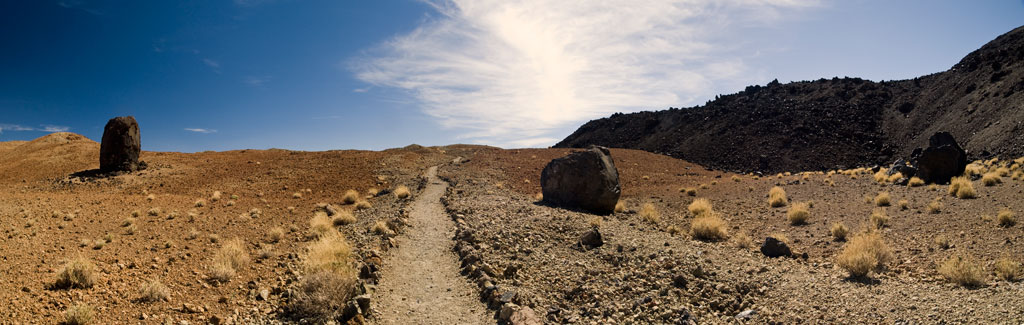 Sendero en paisaje volcánico árido con rocas grandes en el Parque Nacional del Teide, Tenerife.