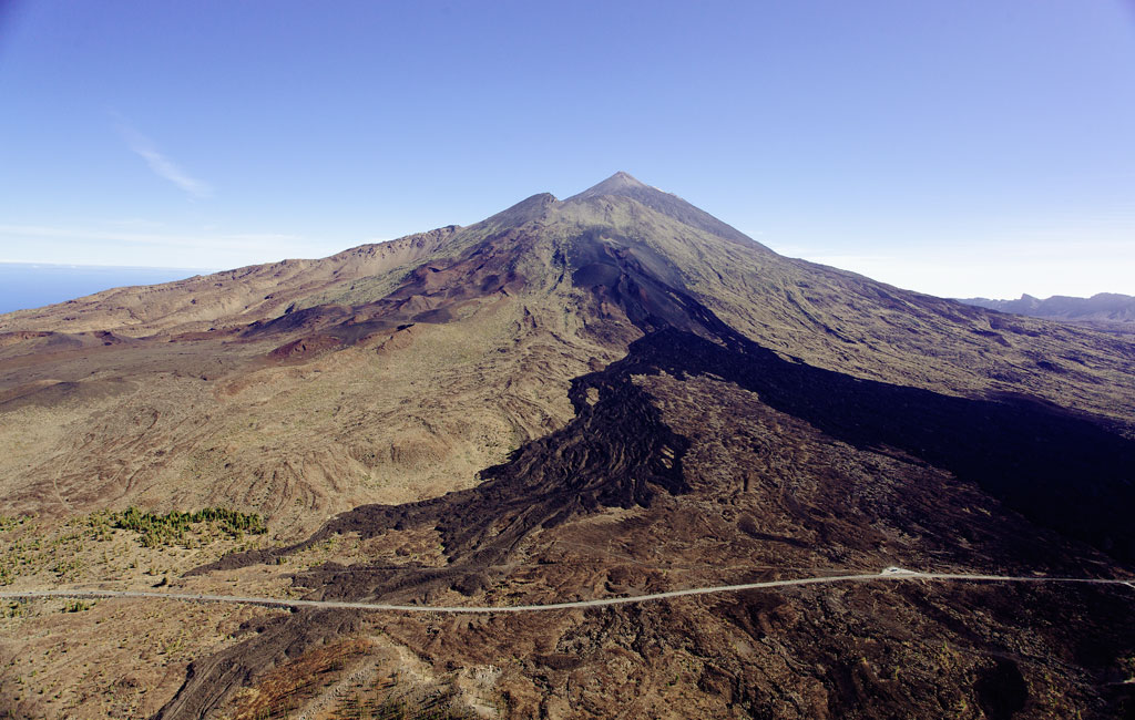 El Teide en Tenerife con cielo despejado y carretera en primer plano.