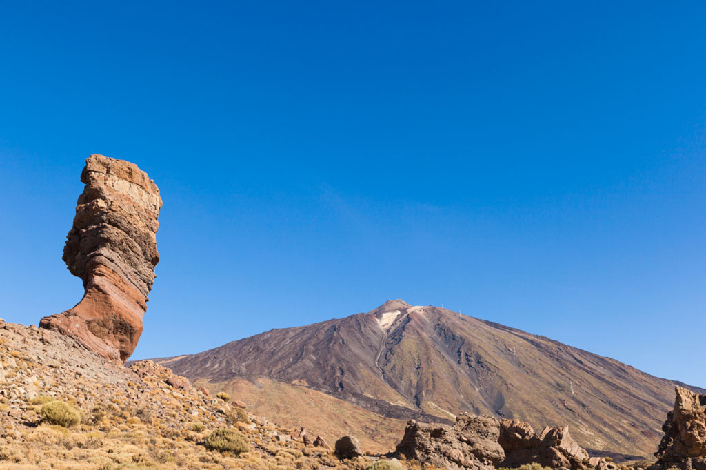 Roque Cinchado con el Teide de fondo en Tenerife bajo un cielo despejado.
