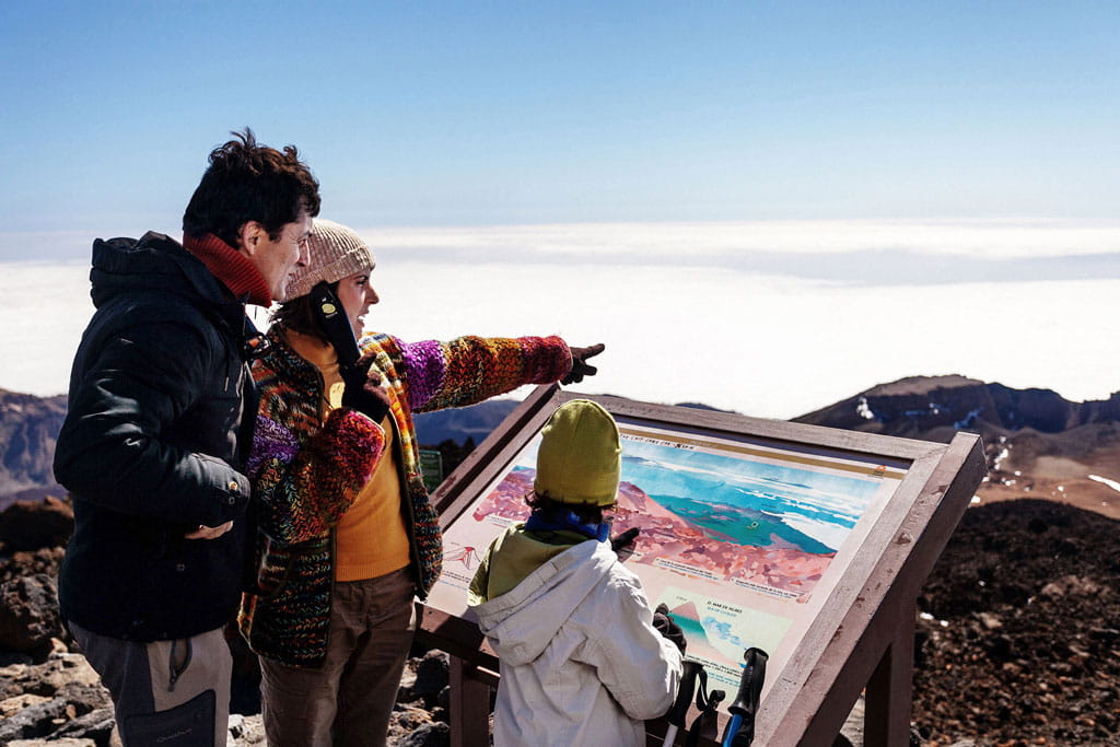 Familia observa un mapa en el Parque Nacional del Teide, Tenerife.