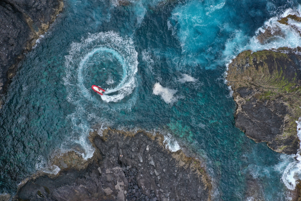 Bote rojo haciendo círculos en aguas costeras de Tenerife.