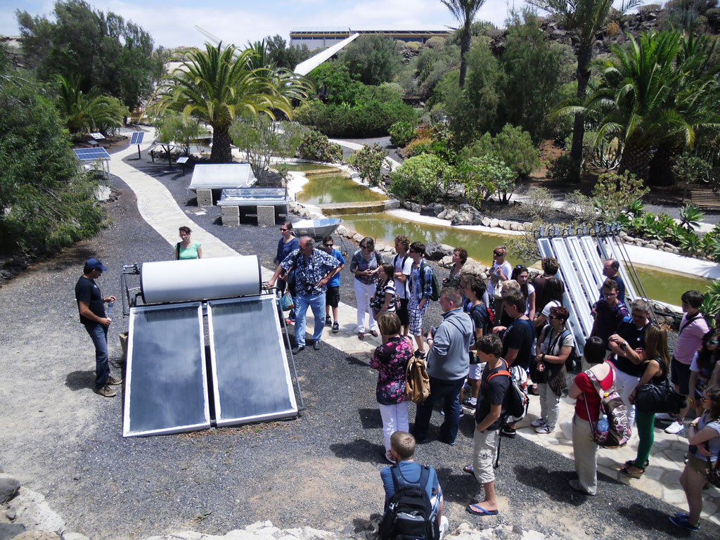 Grupo de personas observando paneles solares en un parque en Tenerife.