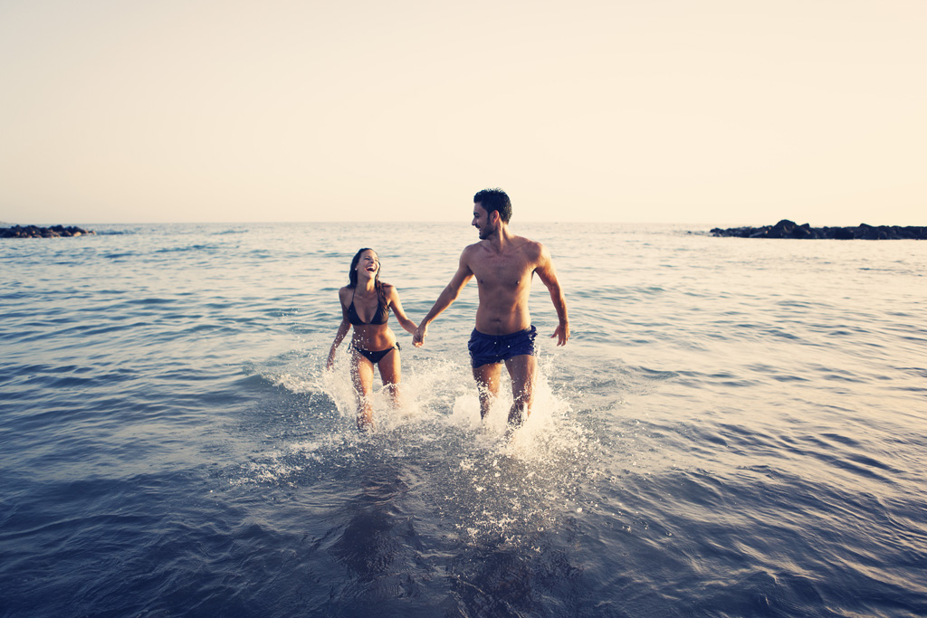 Pareja disfrutando del mar en la playa de Tenerife al atardecer.