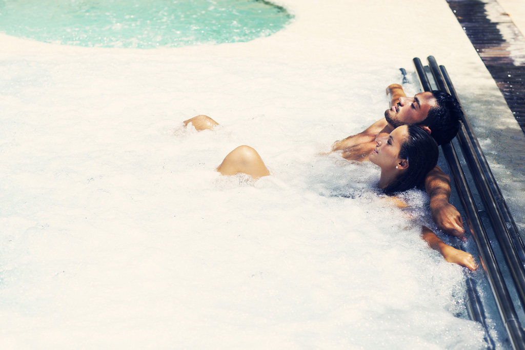 Personas relajándose en un jacuzzi al aire libre en Tenerife.
