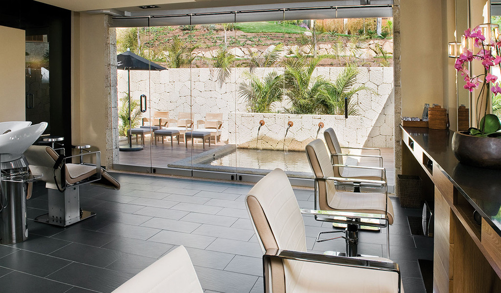 Salón de belleza en Tenerife con vistas a un patio exterior con plantas.