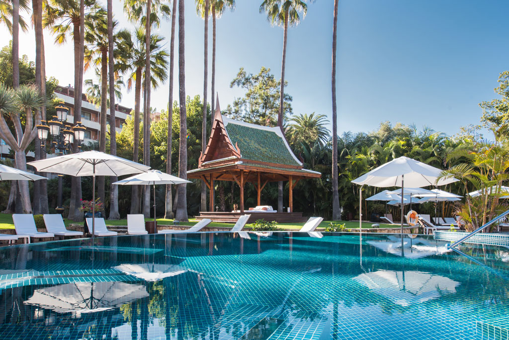 Piscina con sombrillas y cabaña estilo oriental en hotel de Tenerife.