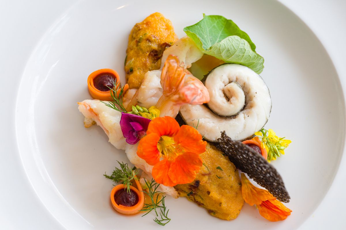 Plato gourmet con mariscos, flores comestibles y puré en Tenerife.