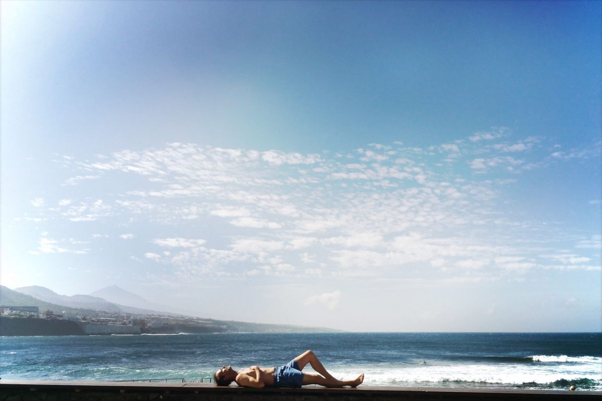 Persona descansando junto al mar en Puerto de la Cruz, Tenerife.