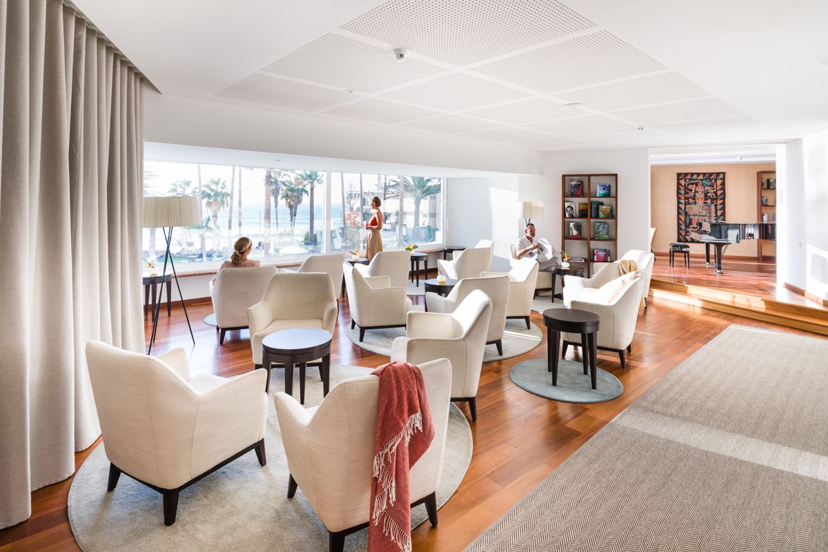 Sala de estar con sillones blancos y vista al mar en Tenerife.
