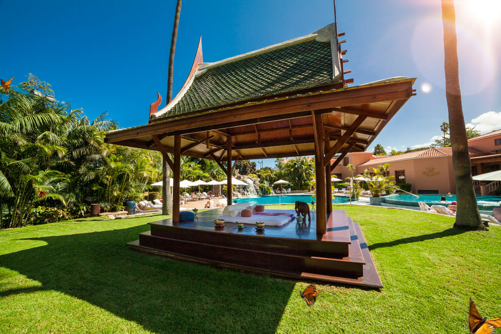 Pabellón de madera en jardín con piscina en hotel de Tenerife.