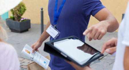 Persona señalando una pantalla de tablet en una calle de Tenerife.