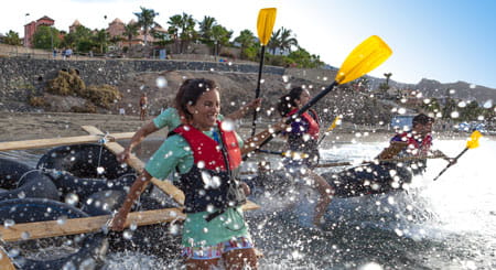 Personas remando una balsa en la playa de Los Cristianos, Tenerife.